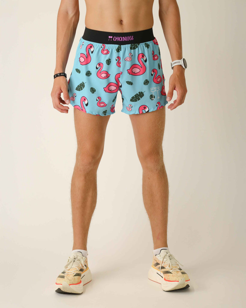 Runner is wearing ChicknLegs in the men's 4 in split running shorts that has a back pocket and an inner liner pocket. The print has pink flamingos on it with green leaves on a blue background.