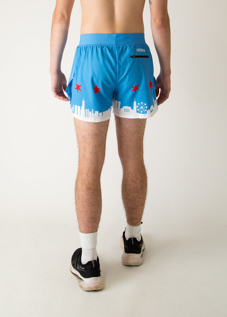 Runner is wearing ChicknLegs in the men's 4 in split running shorts that has the Chicago Style Skylines on it with a white city and blue background with red stars. Includes a back zipper pocket.