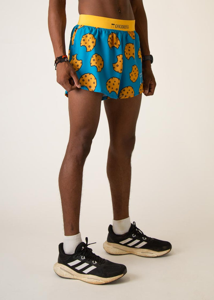 Model wearing Chicknlegs in mens 4 inch split running shorts in the cookies design, facing right.

