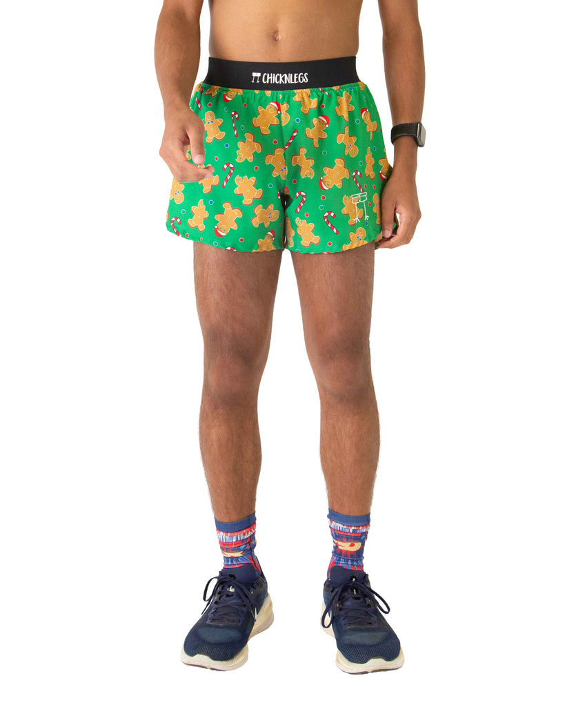 Runner is wearing Chicknlegs in the men's 4 in split running shorts in the gingy's revenge design. The print has gingerbread on it with candy canes in brown, white, green, red, and blue colors.
