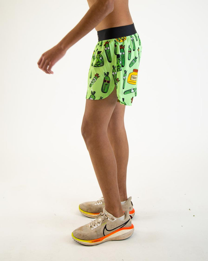 Runner is wearing ChicknLegs in the men's 4 in split running shorts in the pickles design. The print is dark green and light green with pickle jars on it.