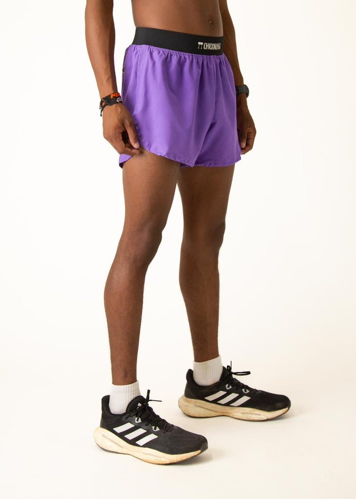 Model wearing Chicknlegs in mens 4 inch split running shorts in the purple design, facing right.
