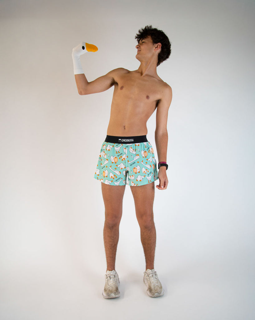 Runner is wearing ChicknLegs in the men's 4 in split running shorts in the Silly Goose Design. Model is posing with a goose sock to match the silly vibe.