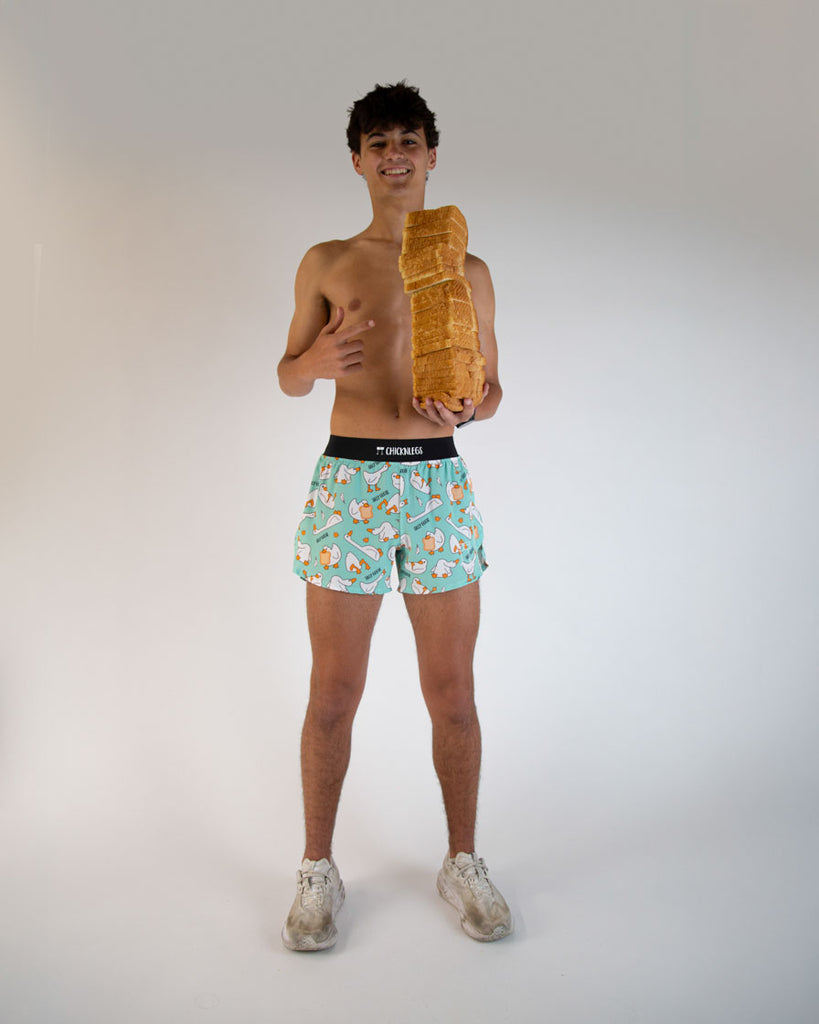 Runner is wearing ChicknLegs in the men's 4 inch split running shorts in the Silly Goose Design. Runner is posing with tons of bread, white, wheat, rye, whole grain, you name it!