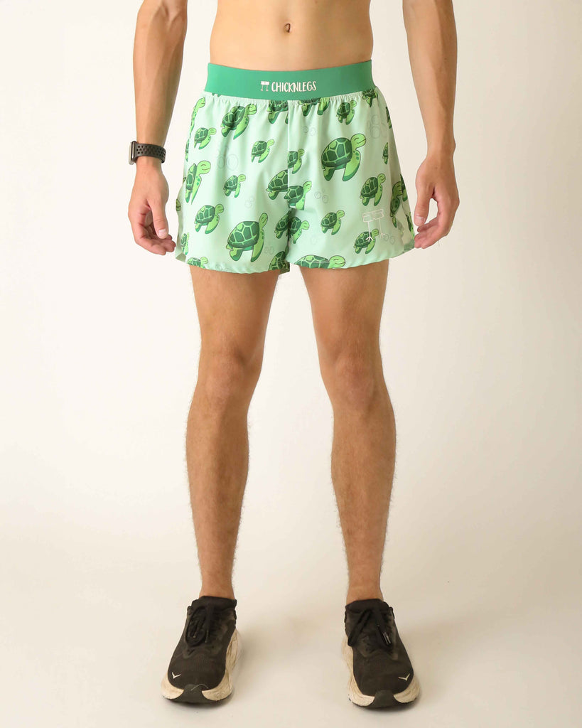 Runner is wearing ChicknLegs in men's 4 in split running shorts with a back pocket and inner liner pocket. The print has sea turtles over it that are green on a light green background.