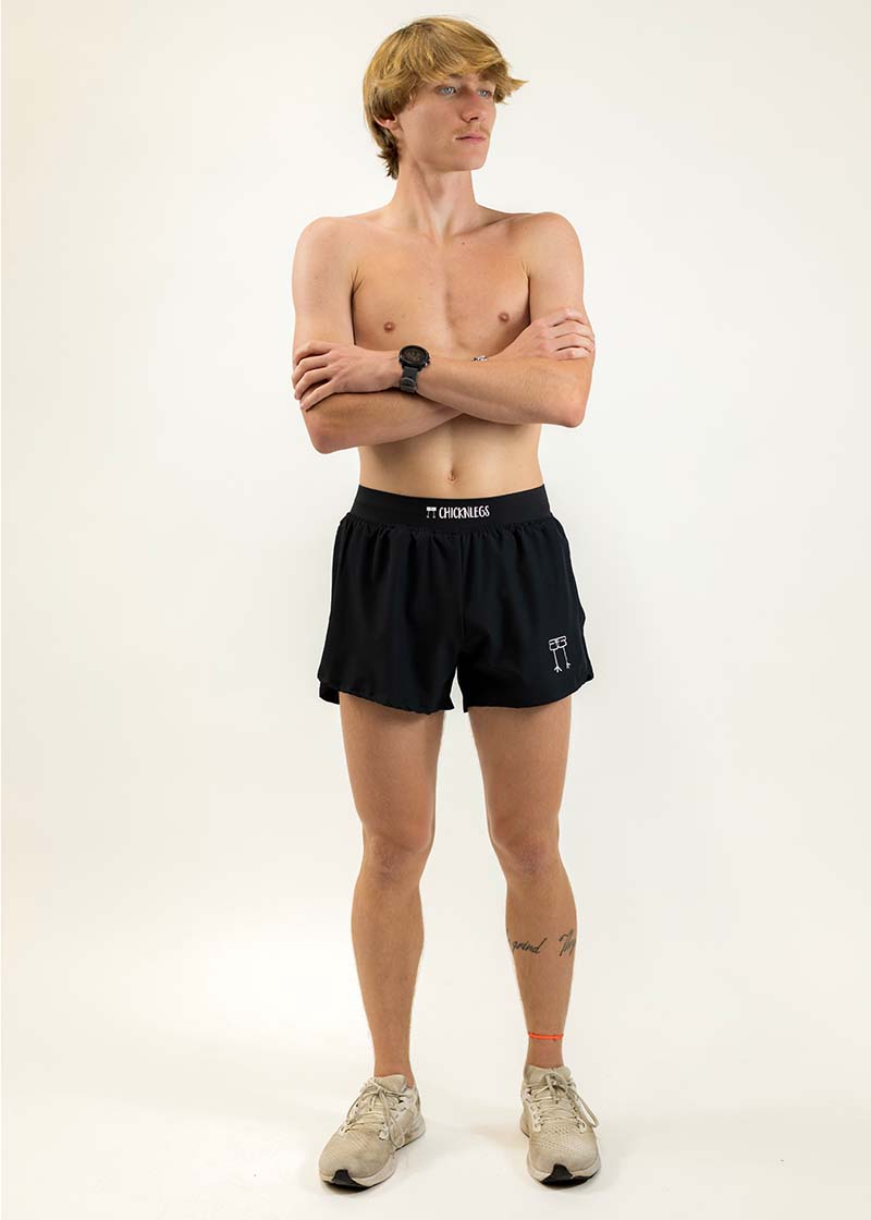 Full body photo of runner wearing the men's 4 inch black split running shorts from ChicknLegs.