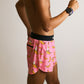 Side view of the men's pink bananas 4 inch split running shorts showing the rear zipper pocket.