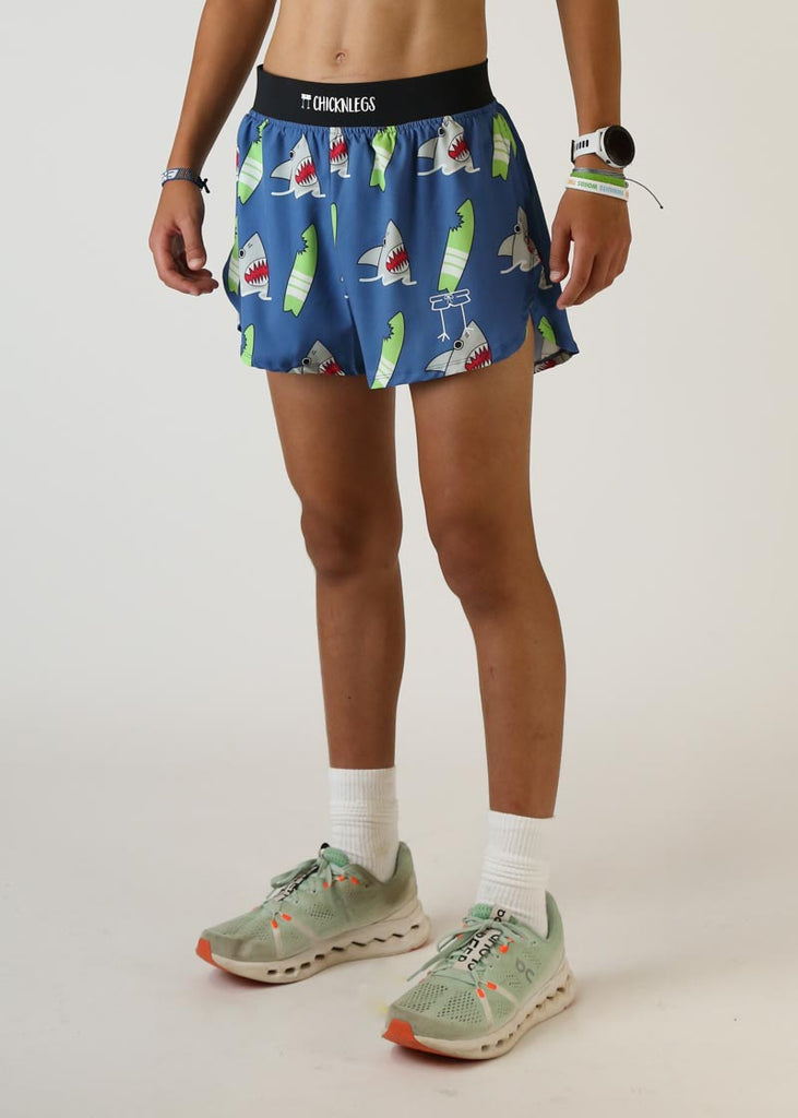 Model wearing Chicknlegs men's 4 inch split running shorts blue shark design left view