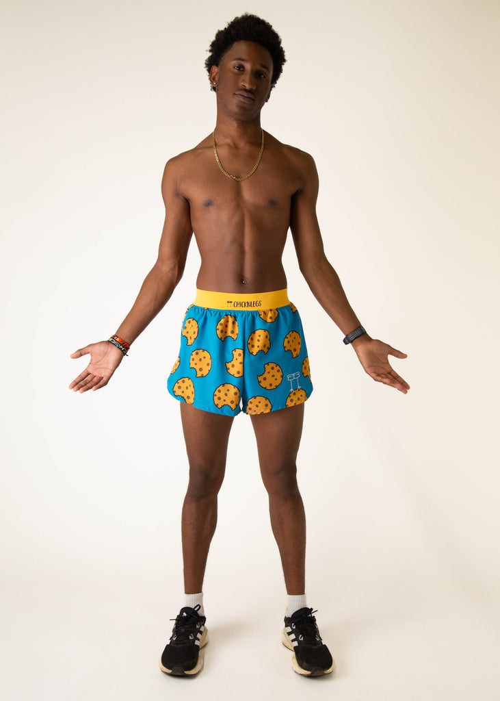 Model wearing Chicknlegs in mens 4 inch split running shorts in the cookies design, facing front while posing and shrugging.