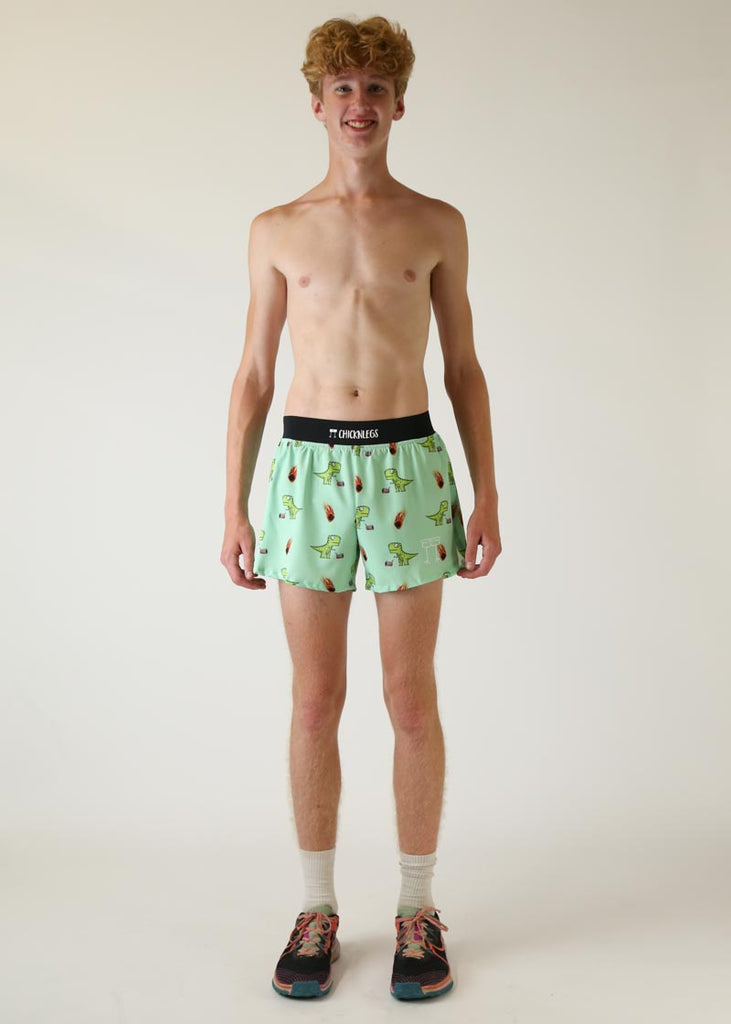 Model wearing Chicknlegs men's 4 inch split running shorts wearing dino design full body pose