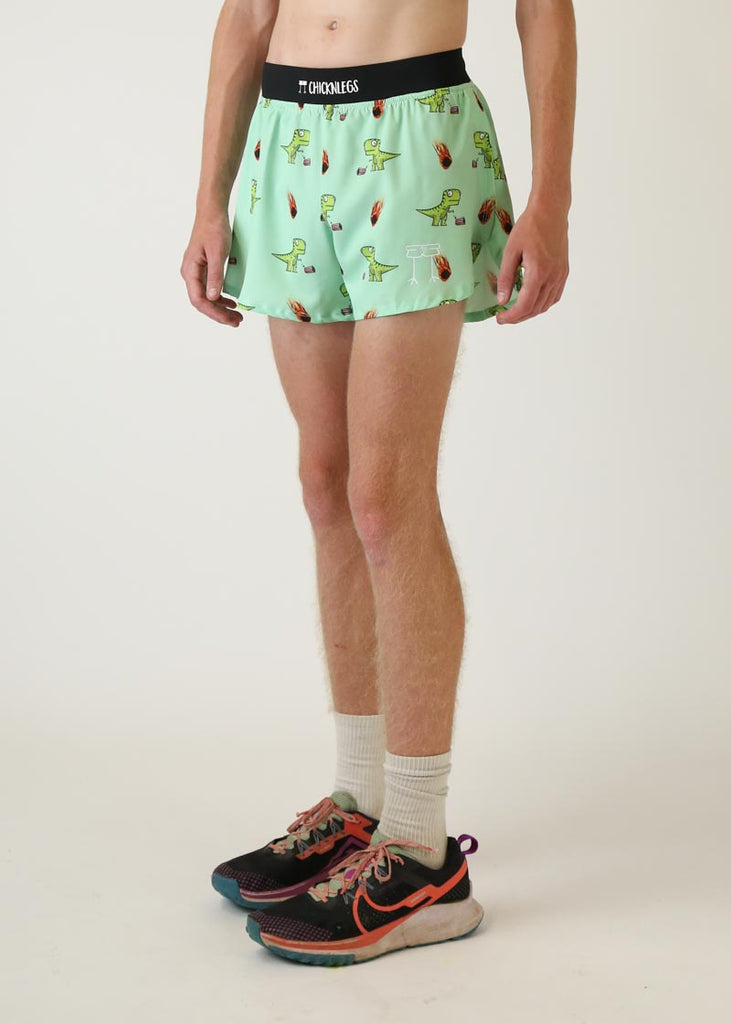 Model wearing Chicknlegs men's 4 inch split running shorts in dinos design left view
