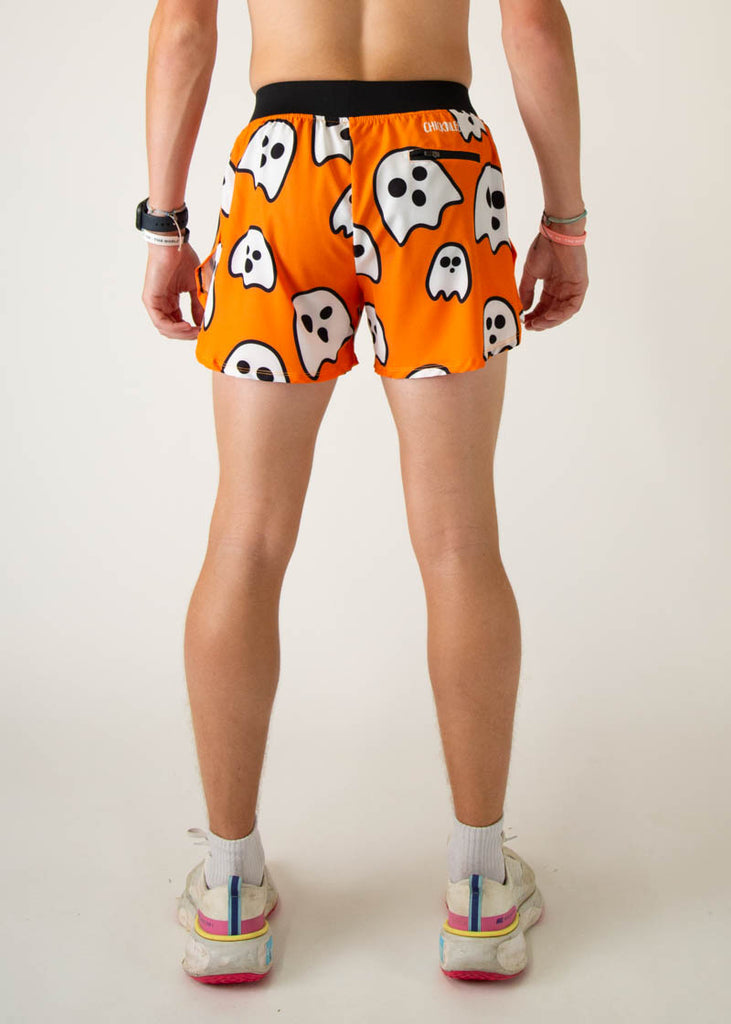 The model is a runner wearing Chicknlegs men's 4 inch split running shorts in the Ghost design, facing away from the camera to show the back of the shorts.
