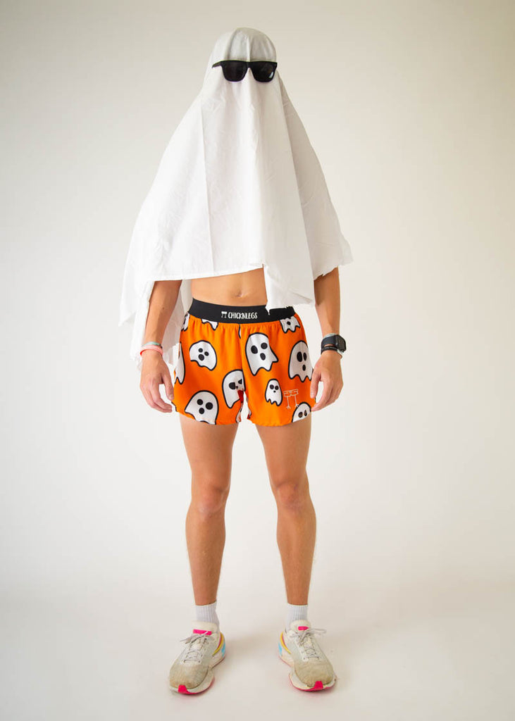 The model is a runner wearing Chicknlegs men's 4 inch split running shorts in the Ghost design, facing front while wearing a sheet to mimic a ghost.