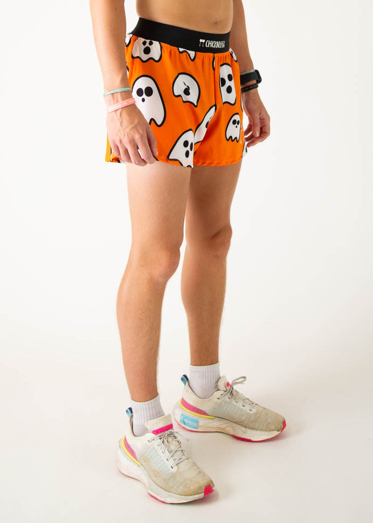 The model is a runner wearing Chicknlegs men's 4 inch split running shorts in the Ghost design, facing right.
