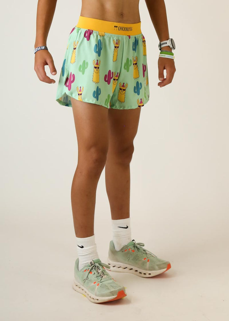Model wearing Chicknlegs men's 4 inch split running shorts green llama design right view