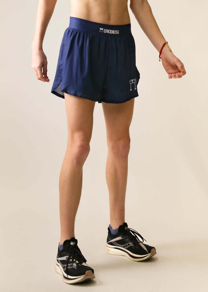 Model is a runner wearing Chicknlegs men's 4 inch split running shorts in the navy blue design facing right.