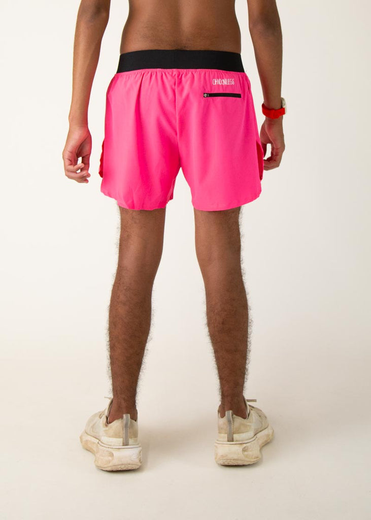 The model is a runner who is wearing Chicknlegs men's 4 inch split running shorts in the neon pink design, facing away from the camera to show the back of the shorts.