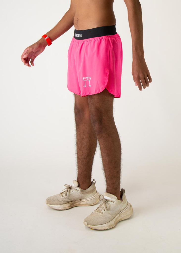 The model is a runner who is wearing Chicknlegs men's 4 inch split running shorts in the neon pink design, facing left.