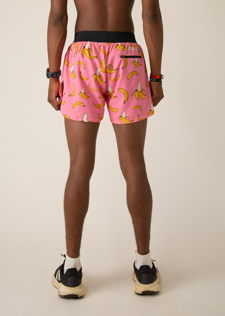Model wearing Chicknleg's mens 4 inch split running shorts in the pink banana design, facing back for the back view.