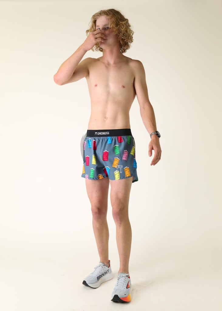 Model wearing Chicknlegs men's 4 inch split running shorts in the porta potty design posing while holding nose and toilet paper.