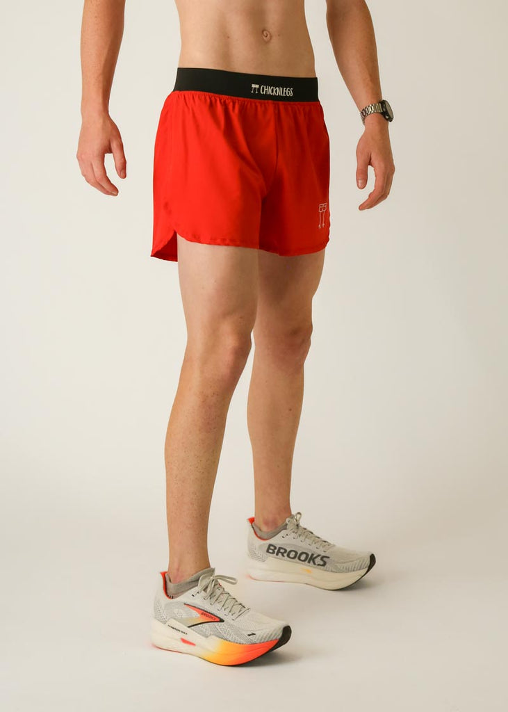 Model is wearing Chicknlegs men's 4 inch split running shorts in the red design, facing right for side view.