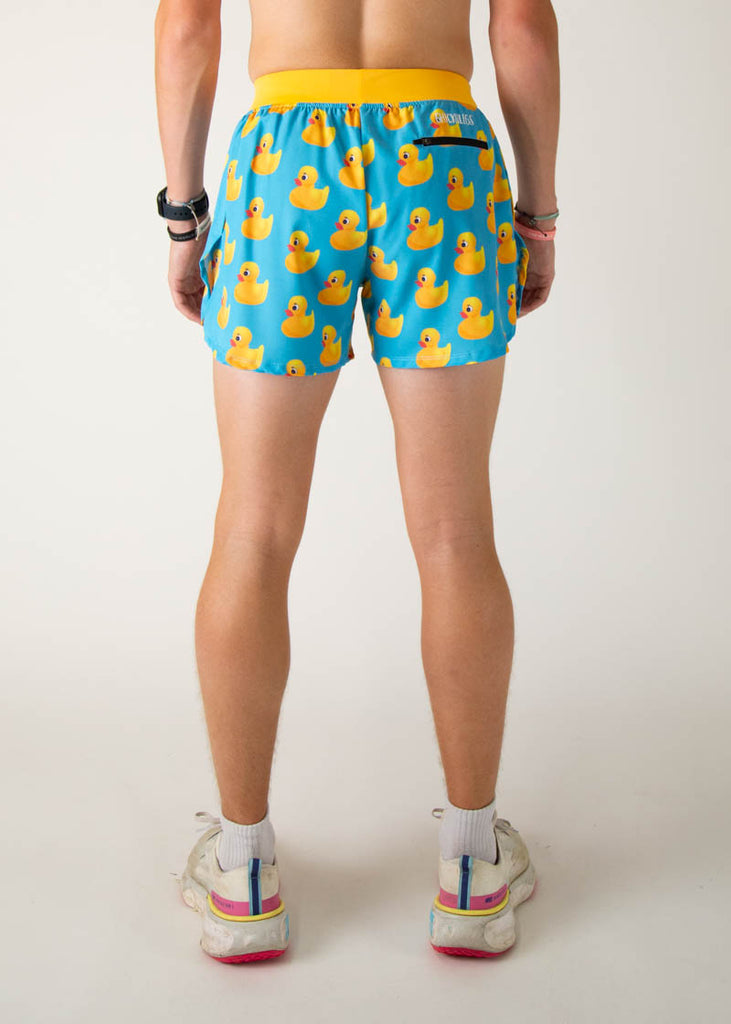 The model is a runner wearing Chicknlegs in the men's 4 inch split running shorts in the rubber ducky design, facing away from the camera to show the back of the shorts.
