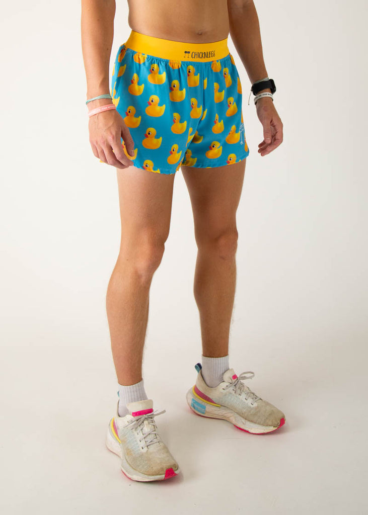 The model is a runner wearing Chicknlegs in the men's 4 inch split running shorts in the rubber ducky design, facing right.
