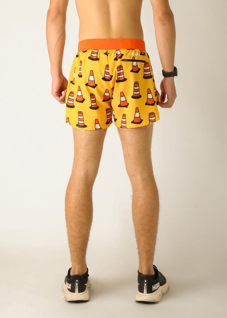 Model is a runner wearing Chicknlegs men's 4 inch split running shorts in the traffic cones design, facing away from the camera for the back view of the shorts.