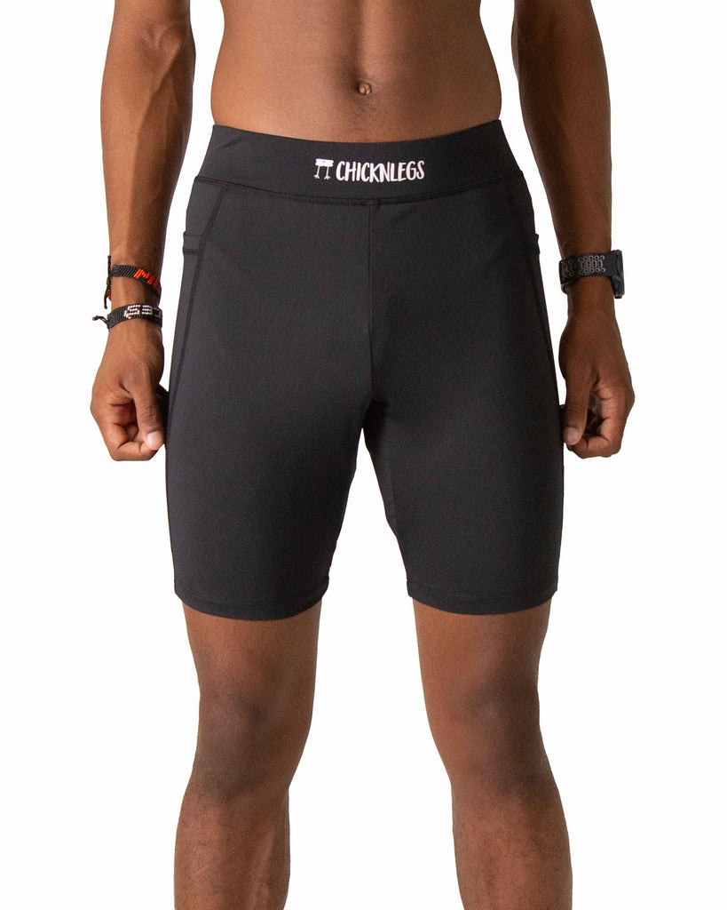Runner is wearing ChicknLegs in the men's 8 in half tights with pockets in the black design. The print has the solid black color.