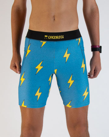 ChicknLegs men's 8 in half tights in the blue bolts design. A close up image is shown of a runner wearing the compression half tights with pockets.