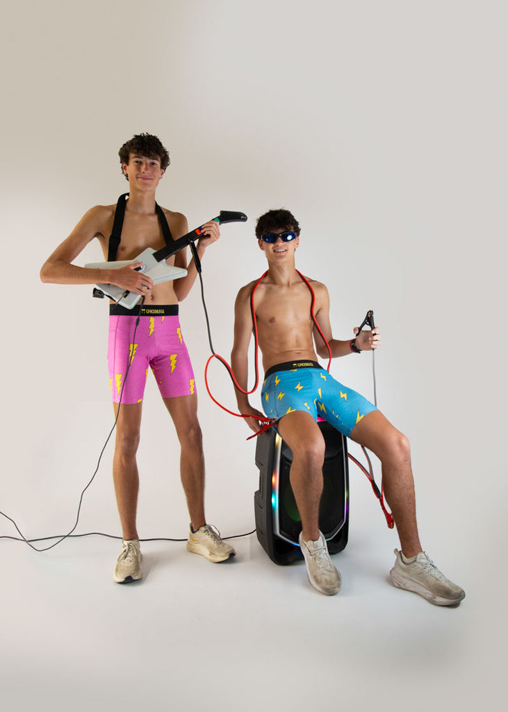 Runner is wearing ChicknLegs in the men's 8 in half tights in the blue bolts design and the hot pink bolts design. The print has yellow lightning bolts on a blue background and on a neon pink background.