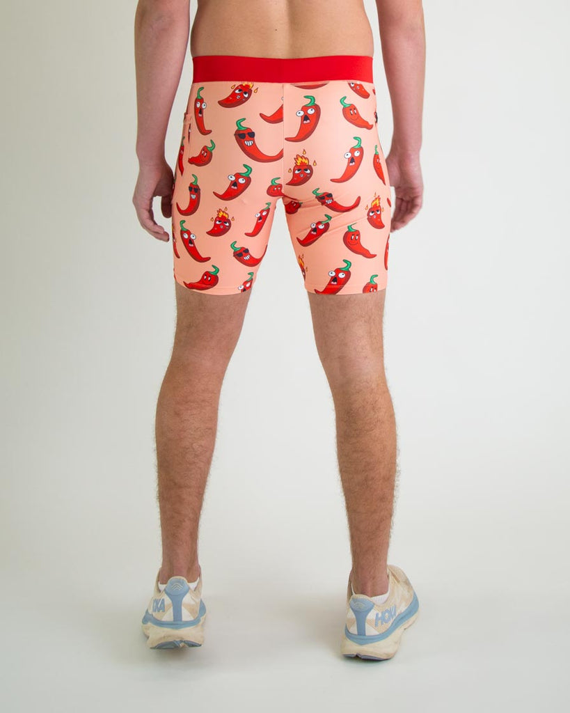 Runner is wearing ChicknLegs in the men's 8 in half tights with pockets in the red hot chili pepper spicy design. The print has red, green and orange on it for the back of the half tights.