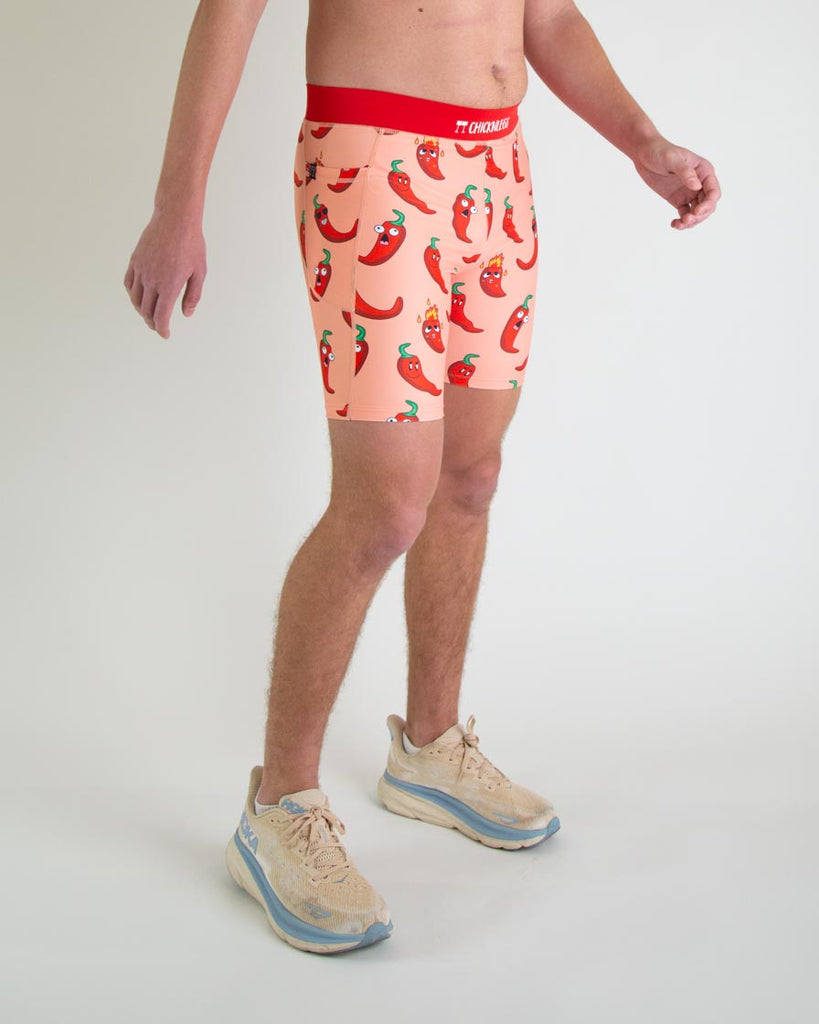Runner is wearing ChicknLegs in the men's 8 in half tights with pockets in the red hot chili pepper spicy design. The print has red, green and orange on it for right view.