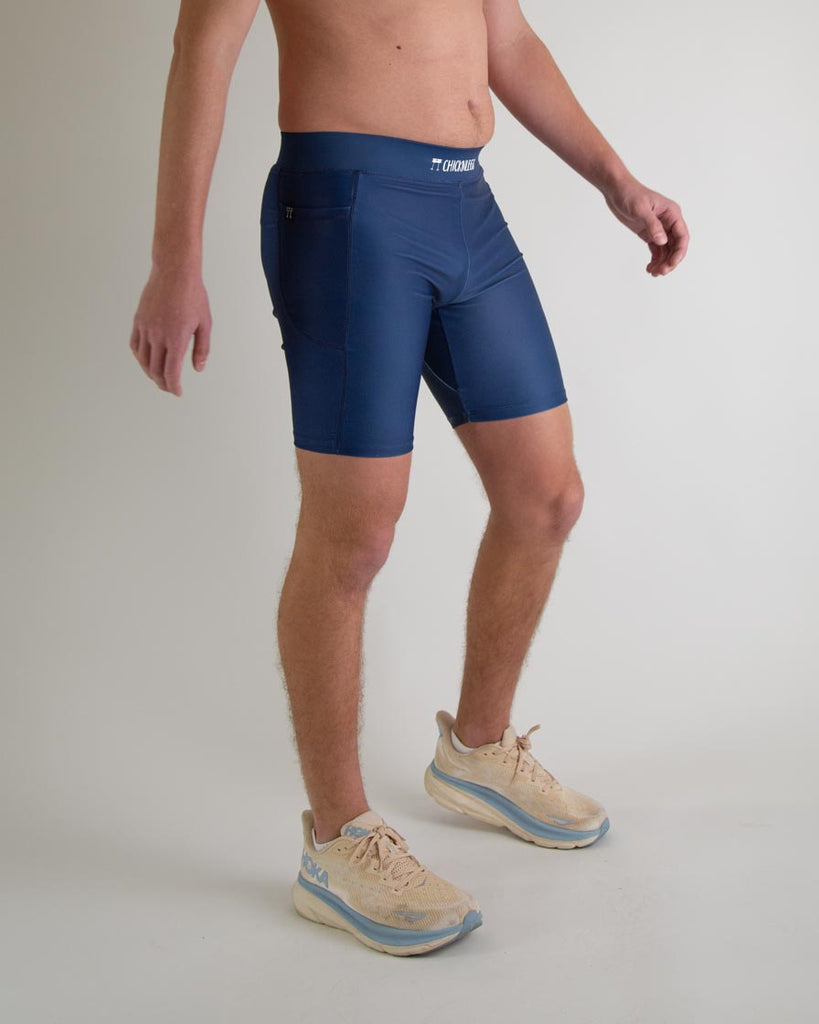 Runner is wearing ChicknLegs in the men's 8 in half tights with pockets in the navy design. The print is a solid navy blue color, great to protect from chaffing and long runs, a right view is shown.