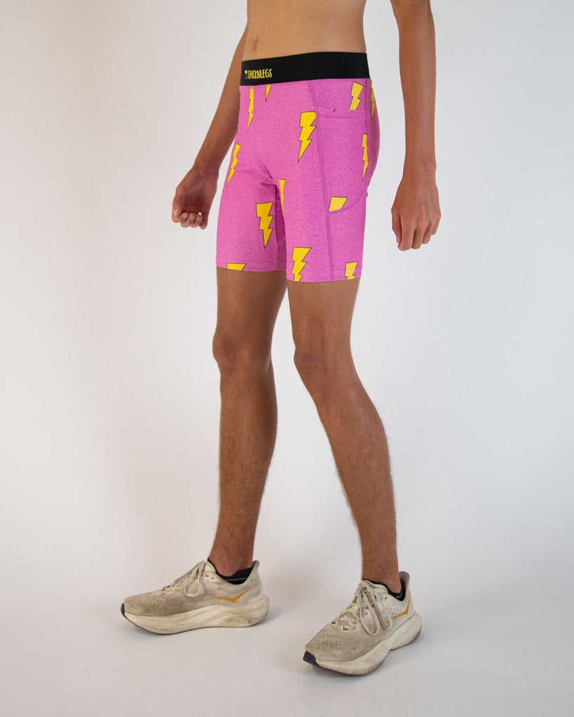 Runner is wearing ChicknLegs in the men's 8 in half tights in the neon hot pink lightning bolts. The print is on bright vibrant pink with yellow bolts. The side of the compression spandex has pockets on the sides good for iphones and apple products as well as androids. 