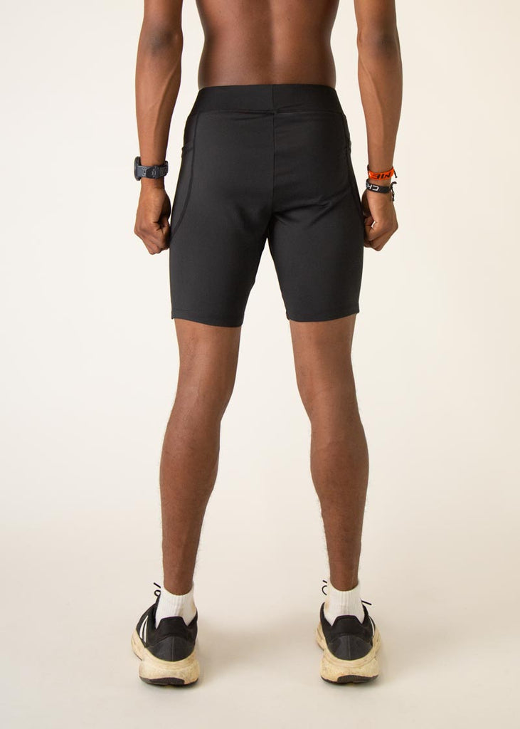 Model wearing Chicknlegs men's 8 inch half tights in the black design, facing away from the camera to show the back of the half tights.