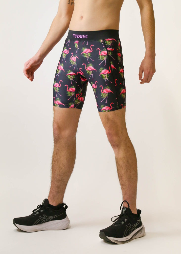 Model is a runner wearing Chicknlegs men's 8 inch half tight with the black flamingo design, facing left.