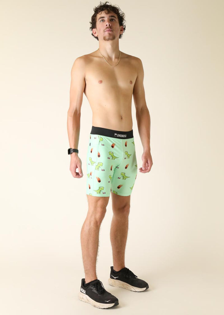 Model wearing Chicknlegs men's 8 inch half tights in the dino's design while standing.