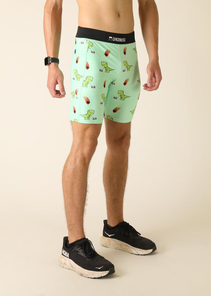 Model wearing Chicknlegs men's 8 inch half tights in the dino's design facing right for side view.