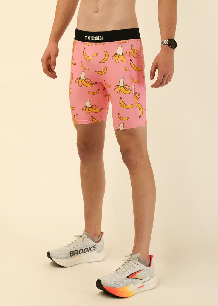 Model wearing Chicknlegs men's 8 inch half tights in the pink bananas design facing left for side view.