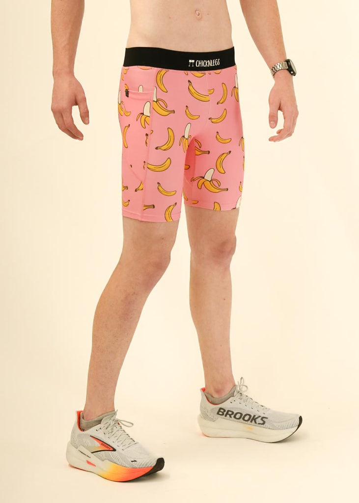 Model wearing Chicknlegs men's 8 inch half tights in the pink bananas design facing right for side view.