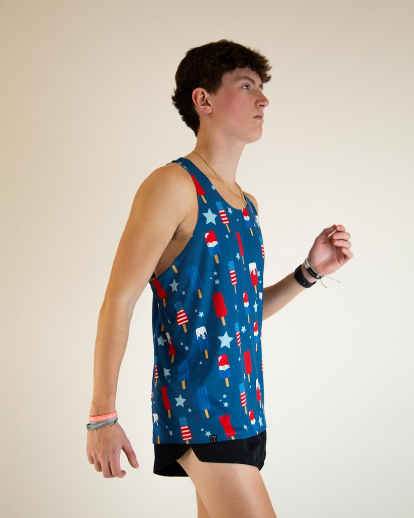 Runner is wearing ChicknLegs men's performance singlet in the USA Popsicle design, facing front. The print has red, white and blue ice cream on it with stars.