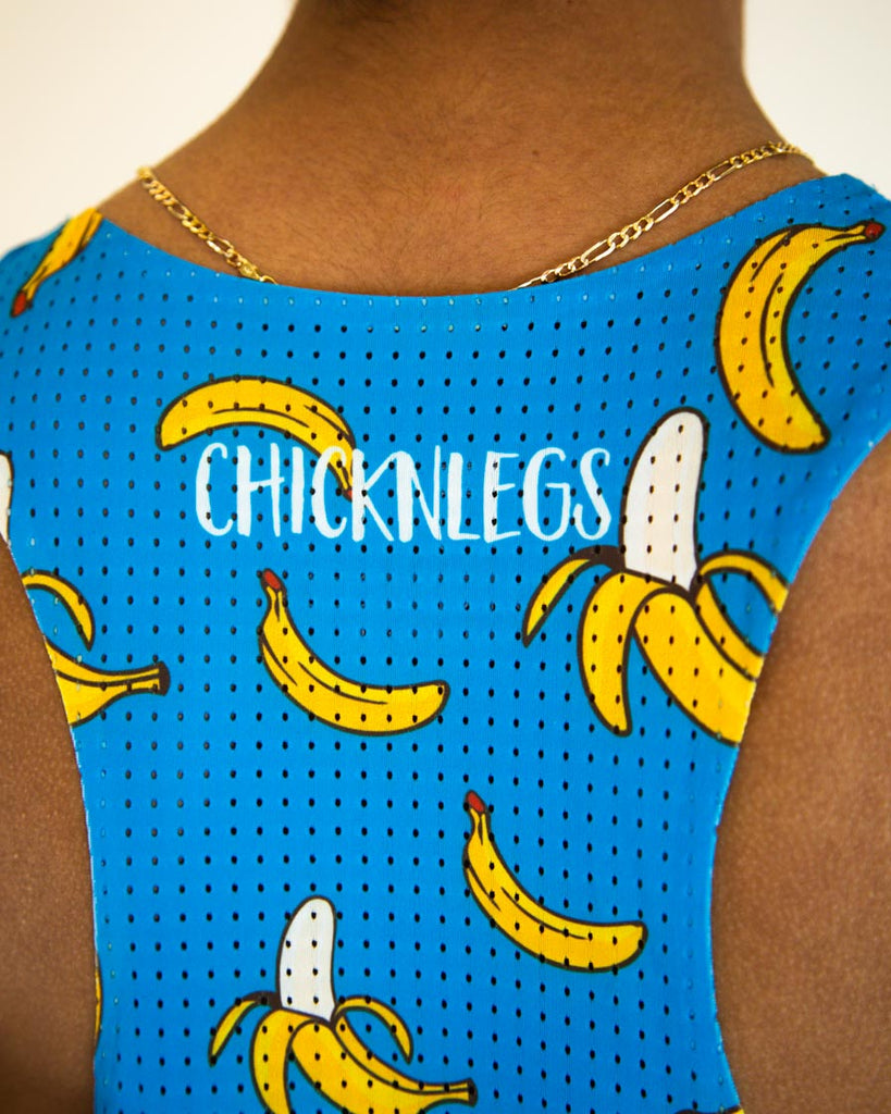 Runner is wearing ChicknLegs men's performance singlet in the blue banana design. A close up image is shown of the material to show how breathable the mesh is.