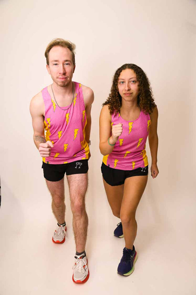 Runners wearing the men's and women's pink bolts performance singlets striking a running pose.