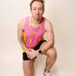 Runner kneeling while wearing the pink bolts performance singlet.