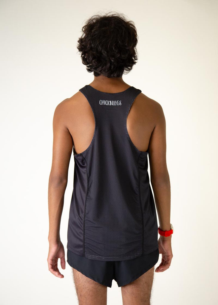 The model is a runner who is wearing Chicknlegs men's running performance singlet in the black design, facing away from the camera to show the back of the shorts.
