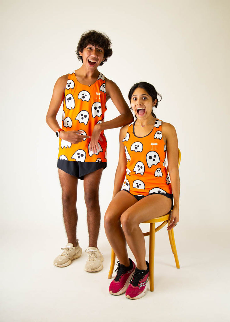 The model is a runner wearing chicknlegs women's runners singlet in the ghost design, facing front while posing with another model who is a runner and wearing the men's ghost singlet looking shocked.