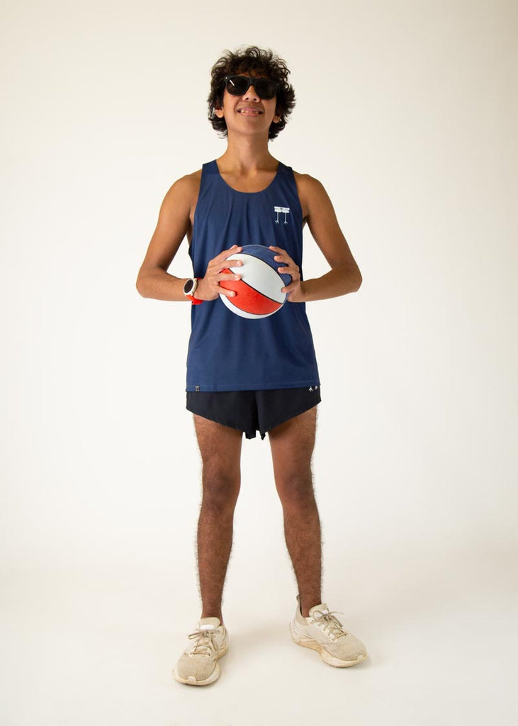 The model is a runner who is wearing Chicknlegs men's running performance singlet in the navy design, posing with a basket ball.