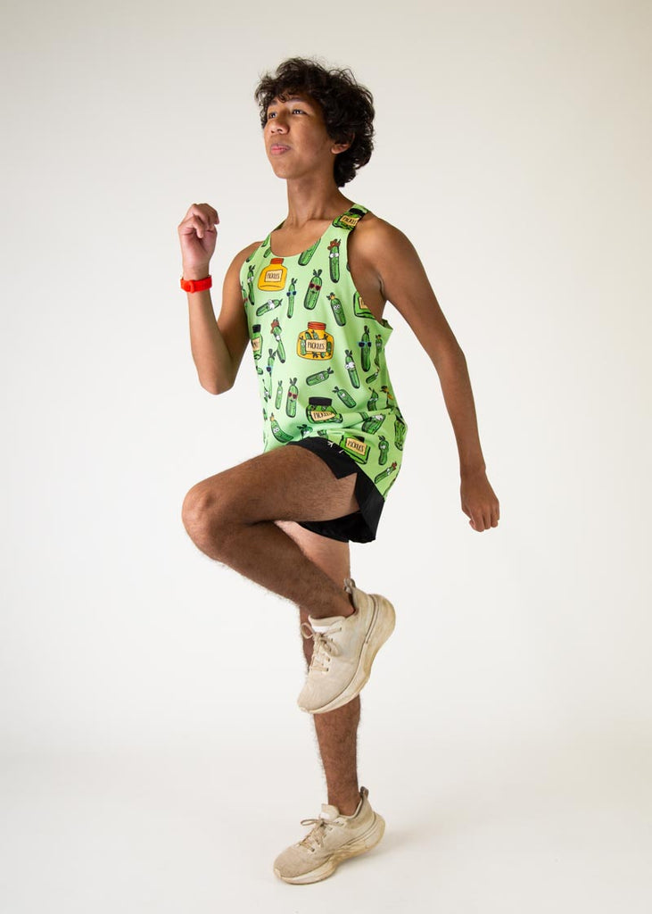 The model is a runner who is wearing Chicknlegs men's running performance singlet in the pickles design, posing in a runners stance about to run.