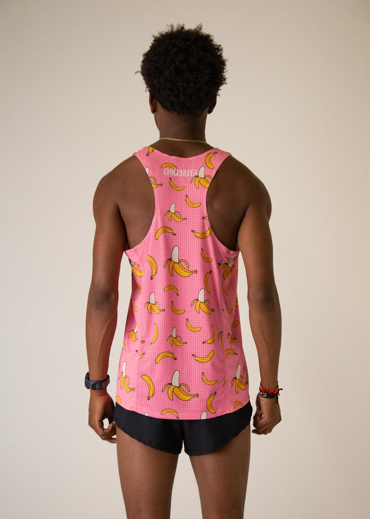 Model is wearing Chicknlegs men's runner singlet in the pink bananas design, facing away from the camera to see the back view of the singlet.